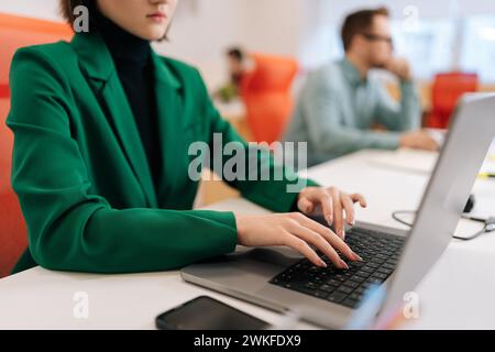 Cropped shot of unrecognizable female developer typing program code on laptop keyboard in coworking. Closeup of young copywriter writing text at work Stock Photo