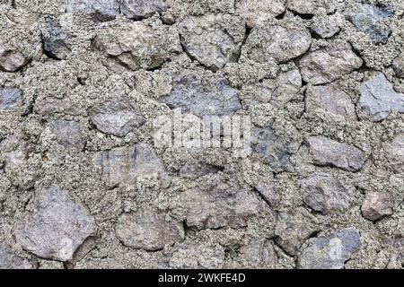 Old gray rough stone wall, background photo texture, front view Stock Photo