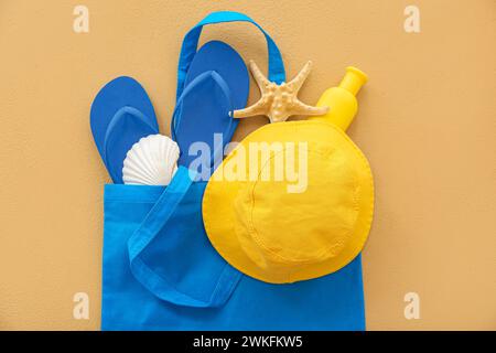 Pair of blue flip flops with bag and beach accessories on beige background Stock Photo
