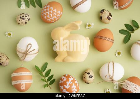 Decorated Easter eggs and toy bunny on green background Stock Photo