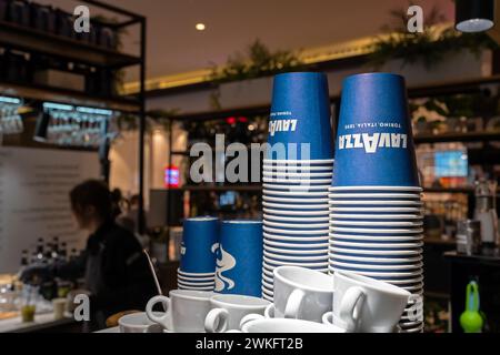 Lavazza brand logo on disposable coffee cups. Lavazza coffee paper cups stack on coffee machine. Minsk, Belarus - february 20, 2024 Stock Photo