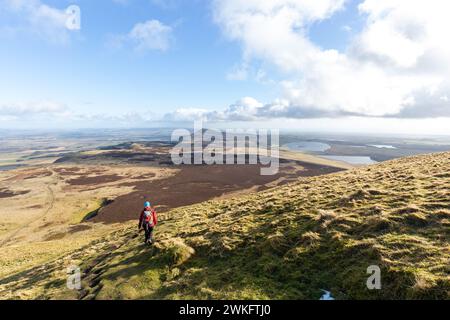 A walker standing just below the summit of West Lomond looking towards East Lomond Hill Stock Photo