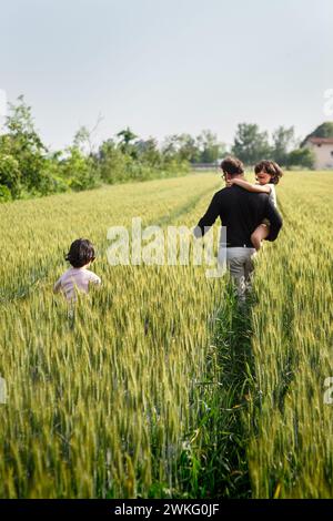 Rear view of father and children walking hand in hand Stock Photo - Alamy