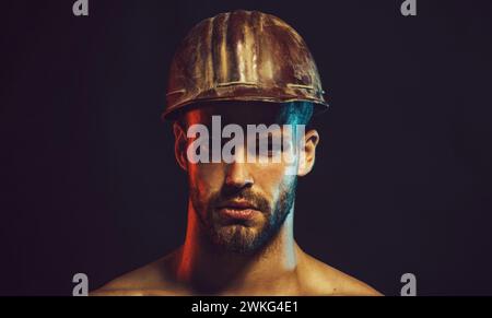 Closeup portrait of bearded architect or engineer in construction helmet. Handsome male builder, contractor, foreman in protective hard hat. Serious Stock Photo