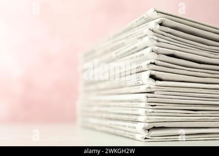 Stack of newspapers on pink background, closeup. Journalist's work Stock Photo
