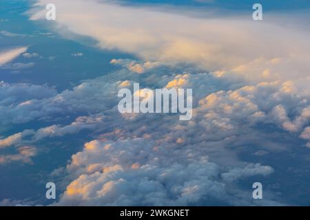 Sunlight through the clouds in the vast blue sky, viewed from the window of an aircraft Stock Photo