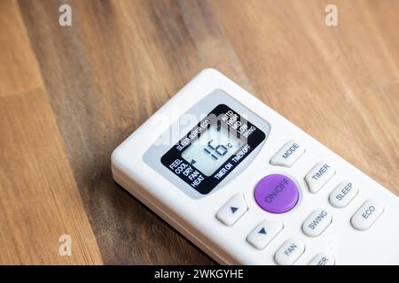 Control of an air conditioner by dialing the number sixteen on a table. Concept of energy consumption. Stock Photo