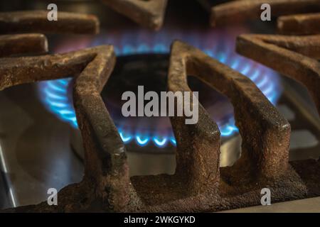 Gas consumption concept. Stove lit with blue light flame. Stock Photo