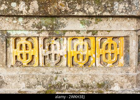 Photograph of traditional Vietnamese ventilation block pattern on an ancient stone wall Stock Photo