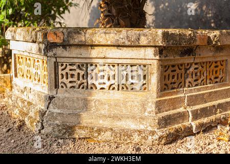 Photograph of traditional Vietnamese ventilation block pattern on an ancient stone wall Stock Photo