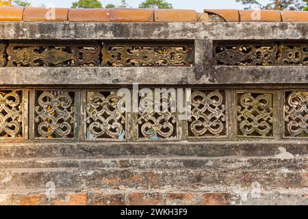 Photograph of traditional Vietnamese ventilation block pattern on an ancient stone wall Stock Photo
