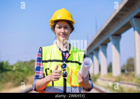 Portrait engineer women on railway tracks construction site with blueprint roll working project manager in suburb transportation line Stock Photo