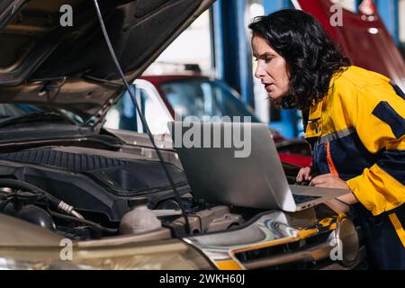 auto mechanic car engineer using laptop computer tuning ECU diagnosis analysis monitor engine problem in garage auto service Stock Photo