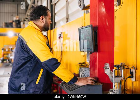 mechanic male worker using advance computer technology for tuning checking analysing car problem in auto salon service workshop Stock Photo