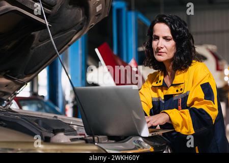 auto mechanic car engineer using laptop computer tuning ECU diagnosis analysis monitor engine problem in garage auto service Stock Photo