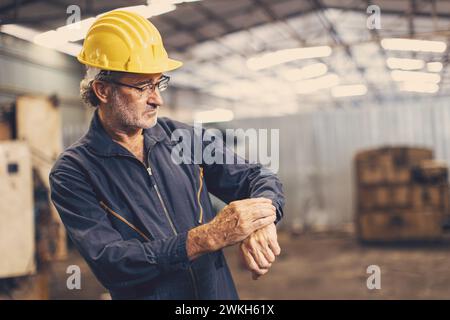senior worker engineer time check looking clock wrist for working in precise schedule times Stock Photo