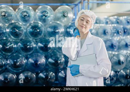 adult women brake relax work in food and drink factory drinking water plant worker tired exhausted gesture. Stock Photo