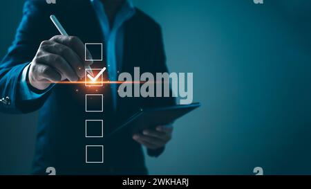 Checklist and filling survey form online. Document management system, DMS. Quality control and accuracy Check, Businessman using tablet online survey Stock Photo