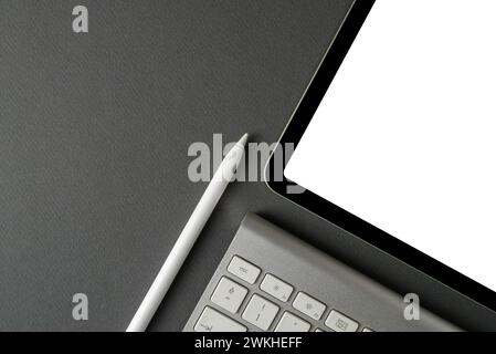 Tablet with blank screen, keyboard and stylus pen on dark gray background Stock Photo