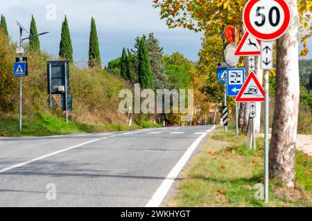 Country asphalt road through the rural region of Tuscany in autumn. Direction to Monteriggioni castle. Stock Photo