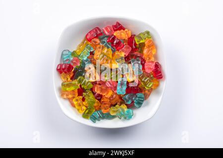 Sweet Delights: Colorful Gummibears in Special Assorted Flavors & Colors in White Bowl. Top View on White Background. Stock Photo