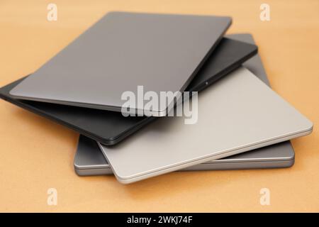 Different modern laptops on brown background, closeup Stock Photo