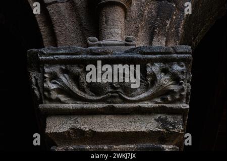 Green Man with foliage sprouting from mouth.  Lombard Romanesque carved stone capital in cloister at the Monastery of Santa Maria de Ripoll in Girona province, Catalonia, Spain. This capital is on the earlier, lower level of the cloister. Stock Photo