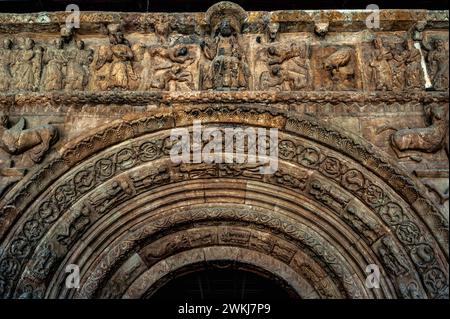 Christ in Majesty, supported by angels, in frieze which surmounts the entrance to the basilica of the Monastery of Santa Maria de Ripoll in Girona province, Catalonia, Spain. The entrance was sculpted in the mid-1100s in Lombard Romanesque style.  On the left of Christ is the angel of St Matthew and on the right the eagle of St John.  On both sides of Christ are the elders of the apocalypse. Stock Photo