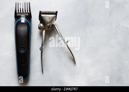 Old and new hair clipper and shaving supplies on white rustic background, barber accessories Stock Photo
