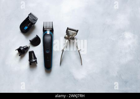 Old and new hair clipper and shaving supplies on white rustic background, barber accessories Stock Photo