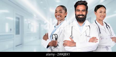 Three confident medical professionals with crossed arms, wearing white lab coats Stock Photo