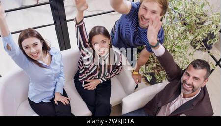 Successful business team stacking hands together. Colleagues celebrating and smiling in an office. Stock Photo