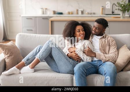 Happy young black couple enjoys casual weekend in living room Stock Photo