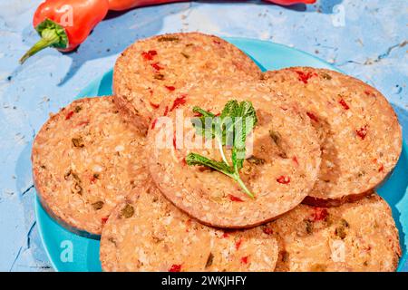 closeup of some slices of a vegan roll, with mushroom and pepper, on a blue plate placed on a rustic textured surface Stock Photo