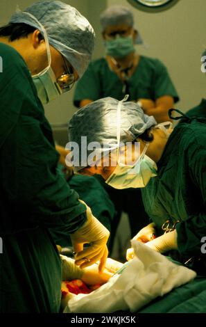 C Section 1980s UK. Dr Maura Stafford, Dr Richard Leech perform a Caesarean section birth at the Royal United Hospital Bath. Dr Phil Hammond in background. Bath, Somerset, England circa 1988. 1980s UK HOMER SYKES Stock Photo
