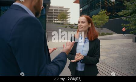 Caucasian businessman and businesswoman coworkers people colleagues partners discussing collaborative project talking business details task talk in Stock Photo