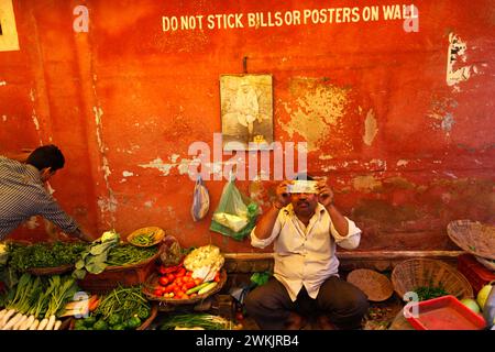 An Indian merchant checks a bank bill on a street in Varanasi, Uttar Pradesh, India. Stock Photo