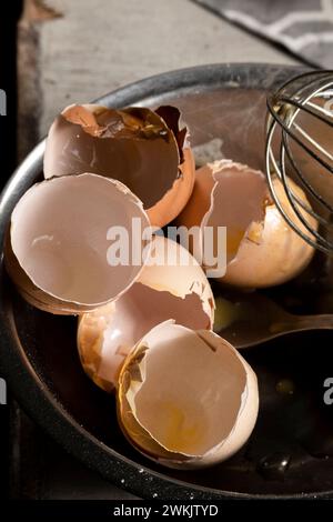 Cracked eggshells and whisk on the table, space for text Stock Photo