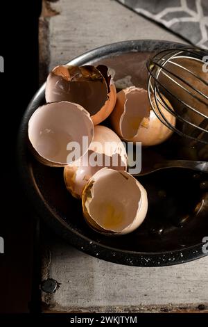 Cracked eggshells and whisk on the table, space for text Stock Photo