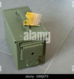 Ammunition box for rifle ammunition with rifle ammunition lying on top. Stock Photo