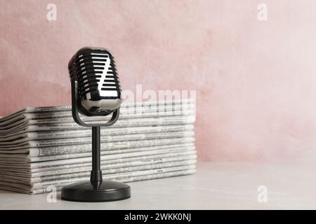 Newspapers and vintage microphone on table, space for text. Journalist's work Stock Photo