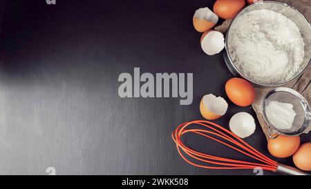 Baking background with ingredients for making gingerbread : flour, eggs, kitchen tools, utensils and on dark wooden table. Top view. Flat lay style. M Stock Photo