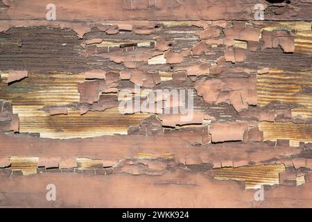 weathered peeling brown paint on a wooden wall Stock Photo