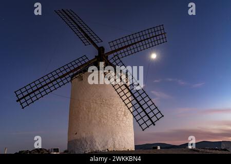 Large windmill in the foreground occupying the entire image of the photo. Windmill at dusk under the moonlight. Stock Photo