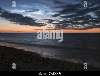 Noctilucent Clouds and dark clouds over the horizon at the Danish beach at sunset dusk twilight Stock Photo