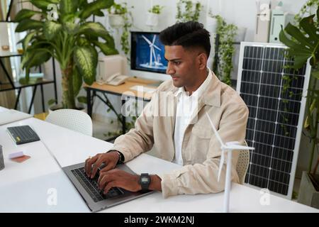 Sustainable energy engineer working on computer at office desk Stock Photo