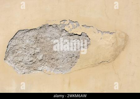 Damage and peeling of plaster on the wall under the influence of atmospheric precipitation. For use as an abstract background and texture. Stock Photo