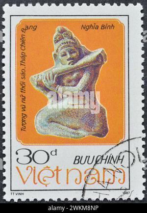 Cancelled postage stamp printed by Vietnam, that shows Woman-playing-flute statue, Architecture and Sculpture of the Chàm People, circa 1987. Stock Photo