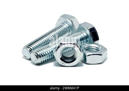 Close up of a couple of silver coloured bolts with accompanying hex nuts isolated against a white background. Stock Photo