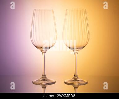 A visually captivating composition featuring a diverse set of glassware illuminated by dynamic colored lighting, presenting an ideal opportunity for c Stock Photo